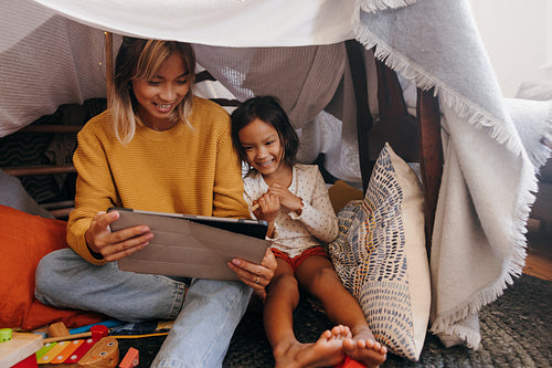 Supportive mother watching kids content with her daughter
