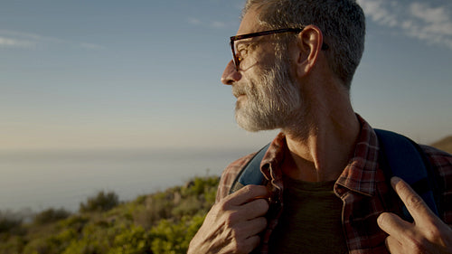 Mature male hiker with backpack looking away