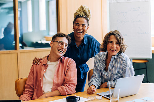 Diverse group of colleagues laughing together during a business meeting