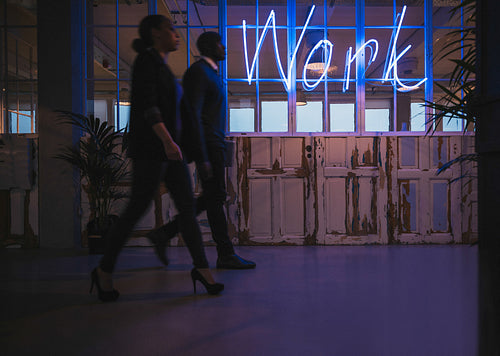 Young business people walking through office corridor
