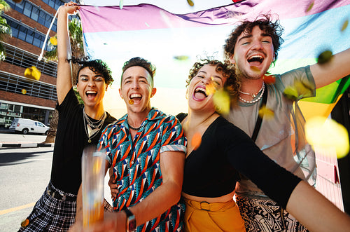 Gender non-confroming group of people celebrating with pride fla