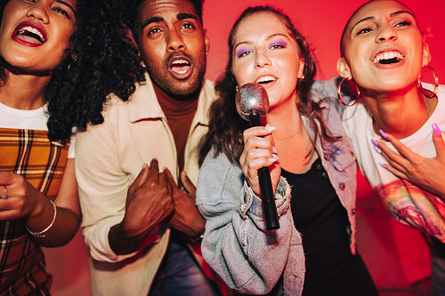 Vibrant friends singing together on karaoke night