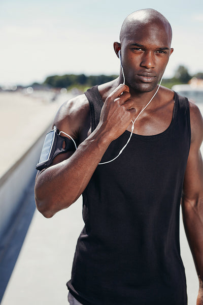 Fit young man outdoors listening to music on earphones