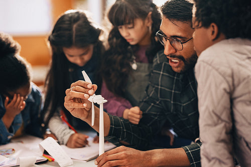 Children learning about renewable energy with a 3D windmill model in science class
