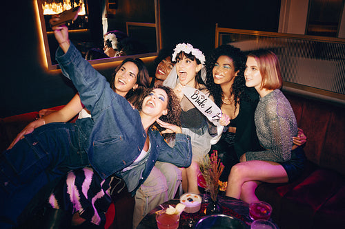 Group of friends celebrating a bachelorette party with a selfie and laughter