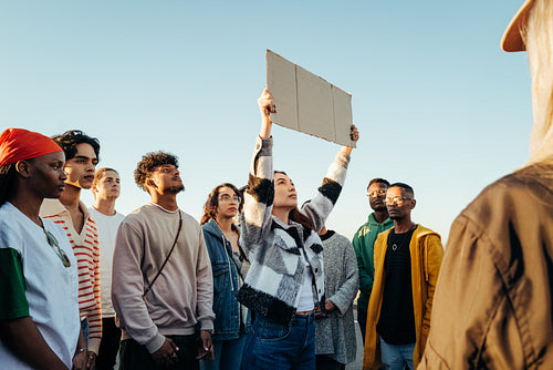 Diverse group of protestors holding a sign during a demonstration outdoors