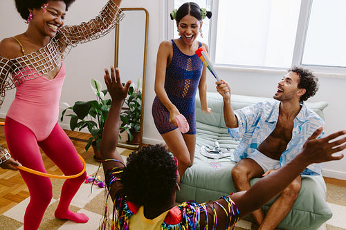 Friends celebrate indoors with dance and props