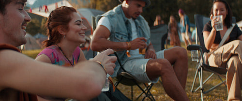 Group of friends cheers drinks at summer music festival