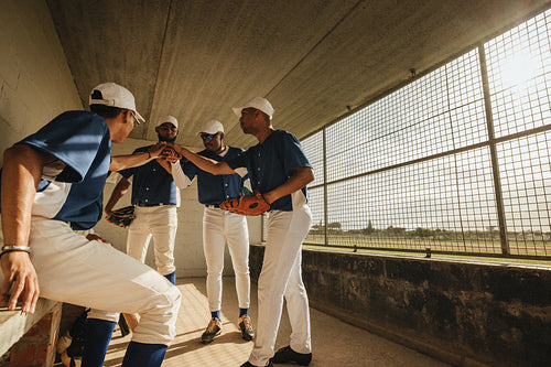 Amateur baseball league players in team huddle in the dugout