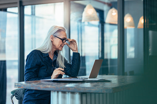 Senior business woman working on laptop in office