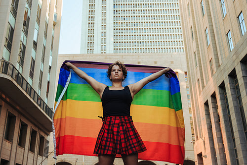 LGBTQ+ member flying the rainbow flag during a pride parade