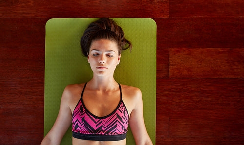 Healthy woman in savasana pose at gym