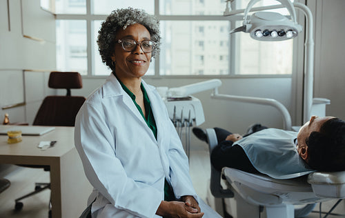 Female dentist portrait with relaxed patient in modern dental office