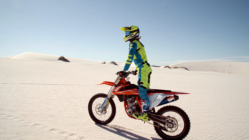 Motorcyclist riding a dirt bike on sand dunes