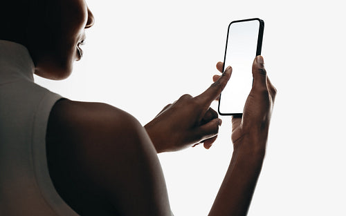 Woman swiping on smartphone with blank screen for technology mockups
