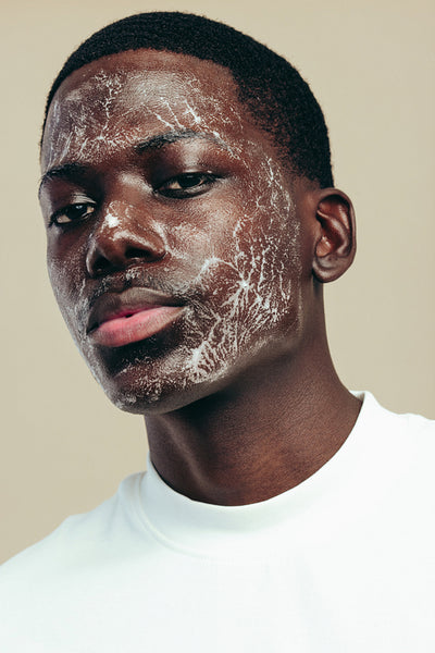Practicing skincare with a face wash: Portrait of a young man using a facial cleanser