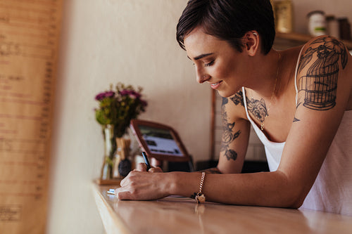 Woman entrepreneur standing at the billing counter of her cafe