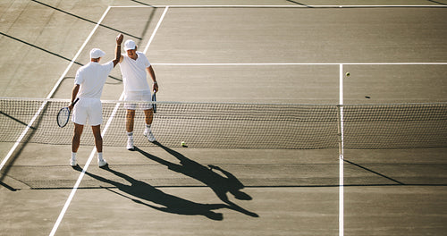 Tennis players giving a high five to each other