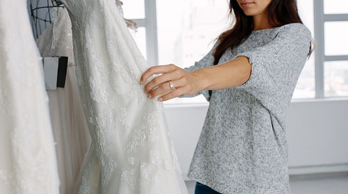Woman looking at bridal gowns on display in boutique