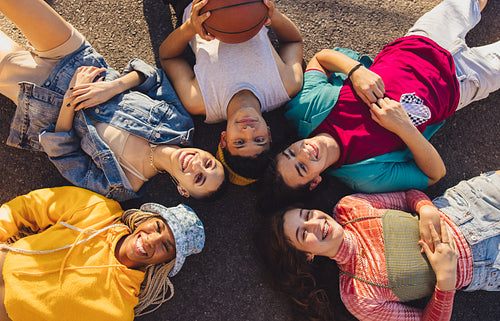 Top view of a group of friends lying on the road