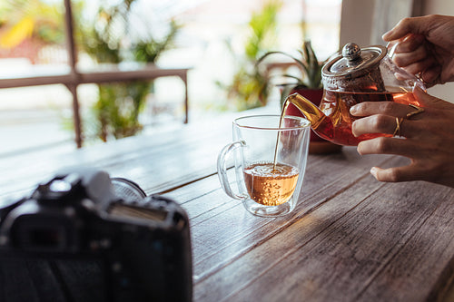 Woman pouring tea in a cup 