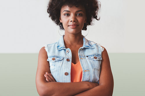 Beautiful young woman standing with her arms crossed