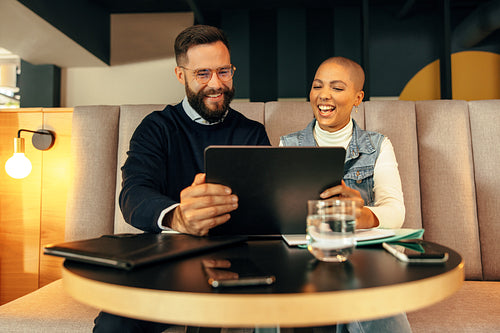 Cheerful entrepreneurs taking a video call on a digital tablet