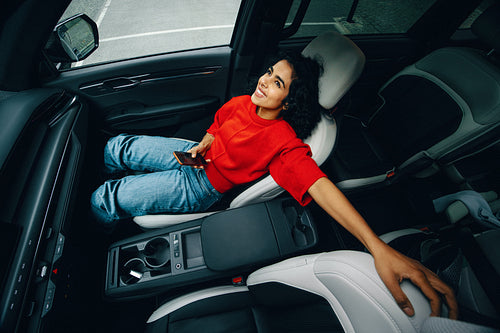 Travel puts the woman at ease as she checks her smartphone in the car