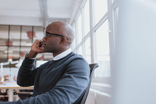 Young man at work answering a phone call