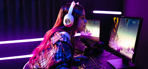 Female gamer playing a first person shooter video game on a pc