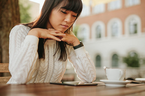 Woman using digital tablet at outdoor coffee shop