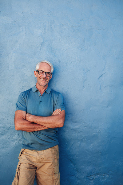 Smiling mature man standing with his arms crossed