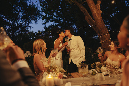 Romantic evening backyard wedding celebration under string lights and outdoor setting