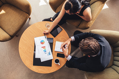 Business colleague sitting at table with charts