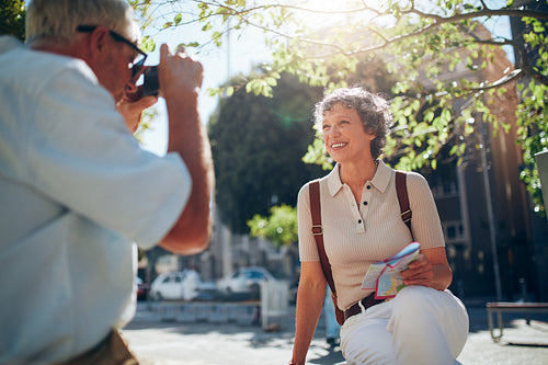 Senior man taking vacation photograph of his wife