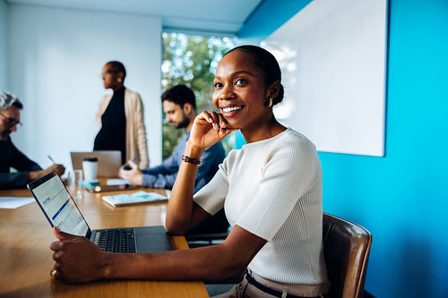 Smiling professional woman sitting at a table during an office meeting
