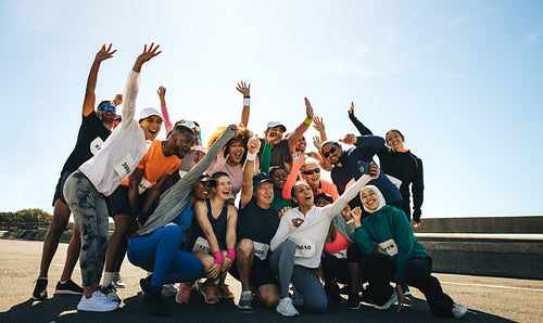 Lively neighborhood running club celebrating together outdoors