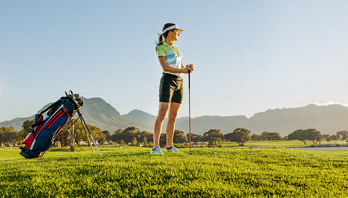Female golfer on golf course waiting to tee off