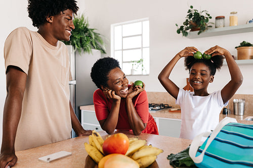 Mom and her kids playing and having fun with fruits at home