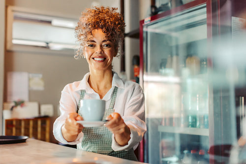 Carefree barista serving a customer in a cafe
