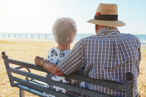 Senior couple sitting on a bench at the seaside