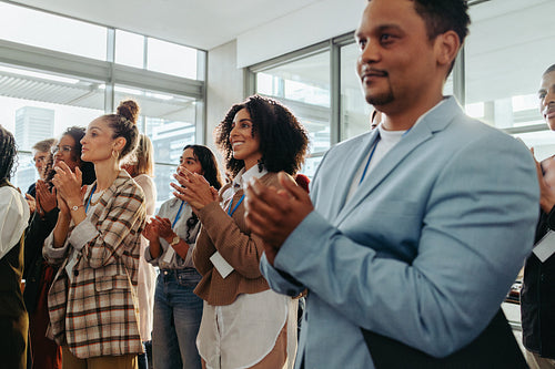 Colleagues clapping during a business presentation at the office