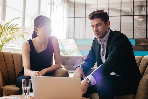 Two business colleagues working on a laptop