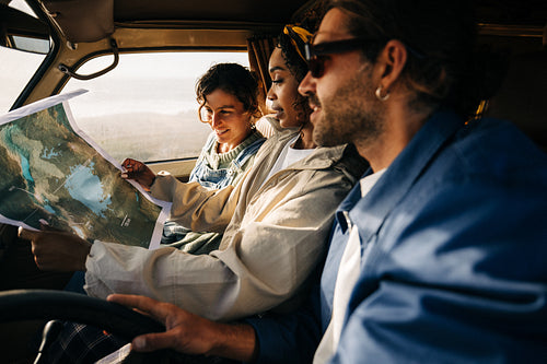 Friends explore a map in a car on a roadtrip