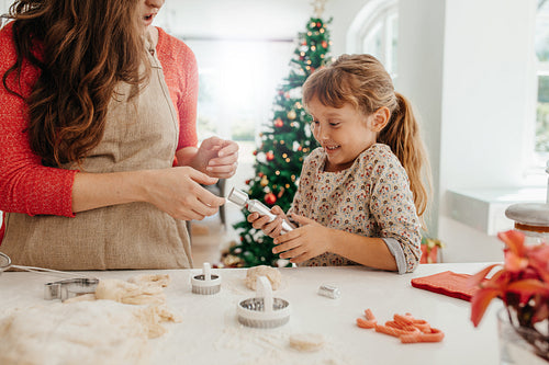Mother and daughter making cookies for Christmas.