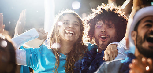 Couple cheering at a live soccer match.