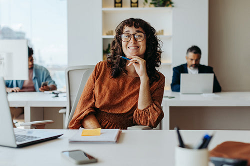 Happy businesswoman planning project at office table