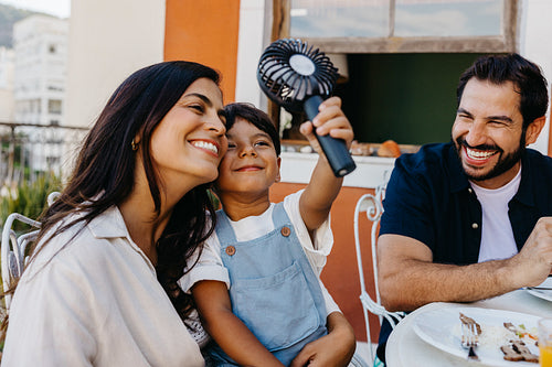 Family enjoying a fun churrasco moment outdoors with smiles and laughter
