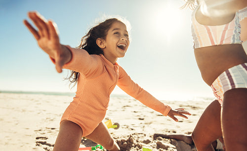 Little girl playing with her friends at the beach