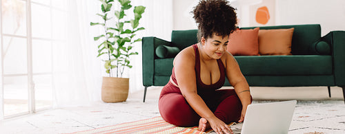 Healthy female using on laptop while workout